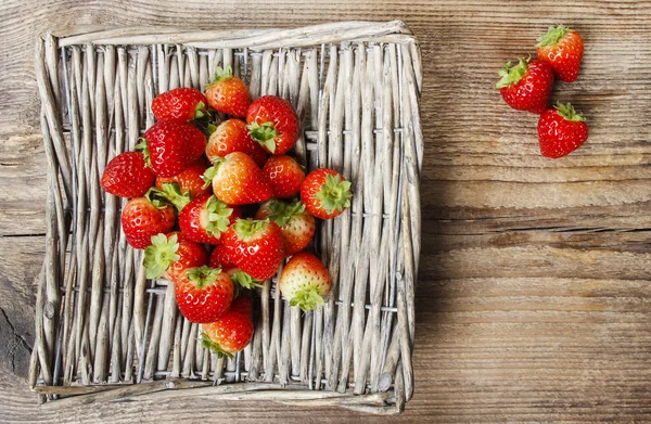 Korb mit Erdbeeren auf Holztisch. Ansicht von oben, Kopierraum — Stockfoto