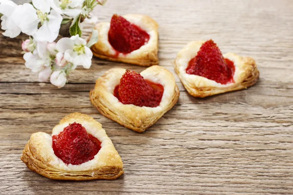 Puff pastry cookies in heart shape filled with strawberries. Blo — Stock Photo, Image