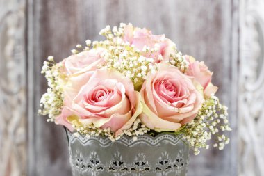 Bouquet of pink roses in rustic bucket clipart