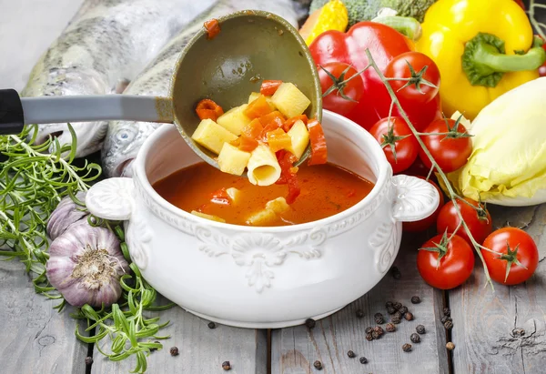 Bowl of tomato soup on wooden table among variety of vegetables — Stock Photo, Image
