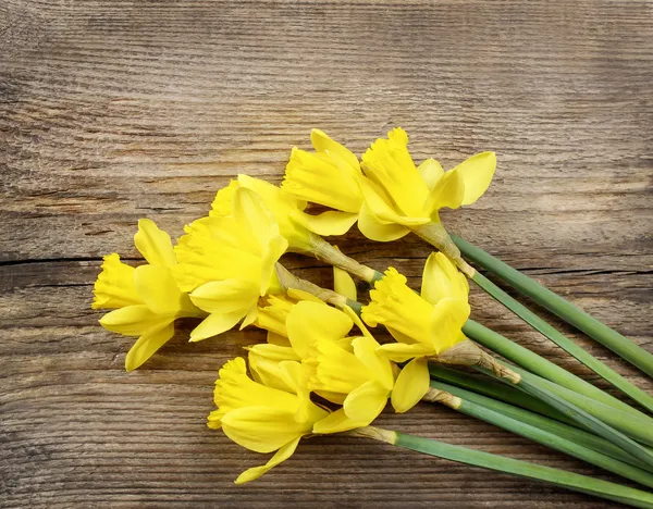 Yellow daffodils on wooden background — Stock Photo, Image