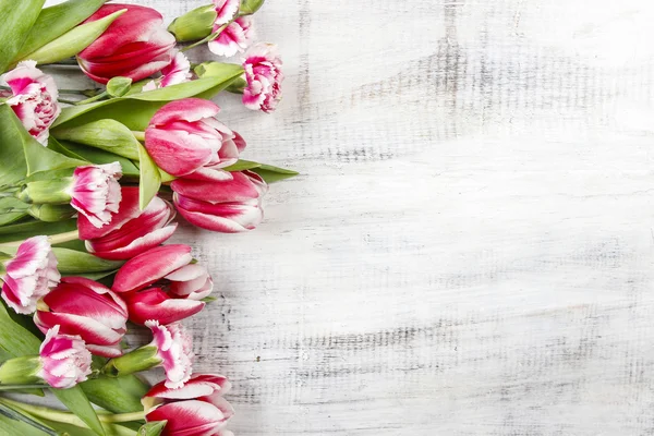 Beautiful red tulips and carnations on wooden table. Top view, c — Stock Photo, Image