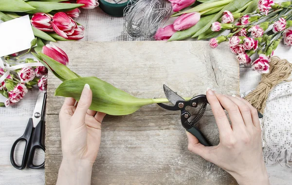 Květinářství v práci. žena dělat jarní květinové dekorace — Stock fotografie