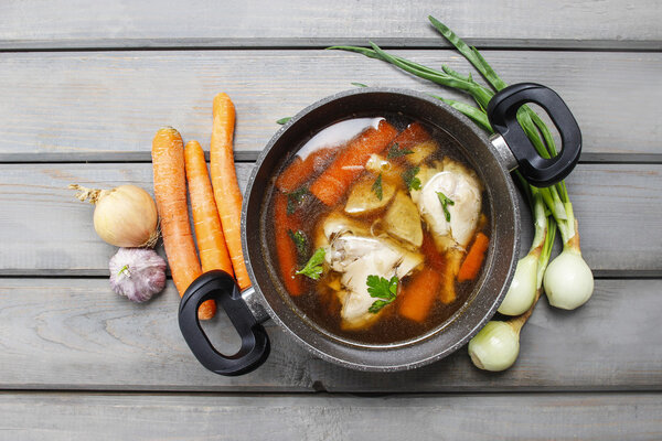 Top view of chicken soup on wooden table