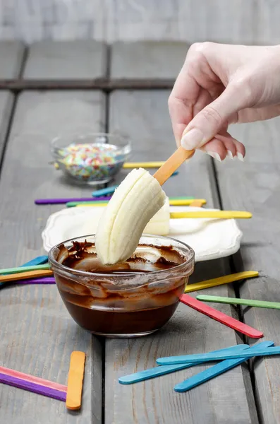 Preparing chocolate dipped banas dessert — Stock Photo, Image