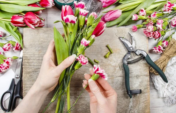 仕事で花屋。女性の春の花飾りを作る — ストック写真