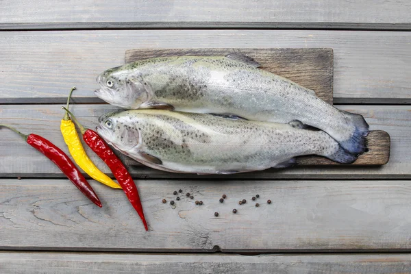 Two rainbow trouts on rustic wooden table — Stock Photo, Image