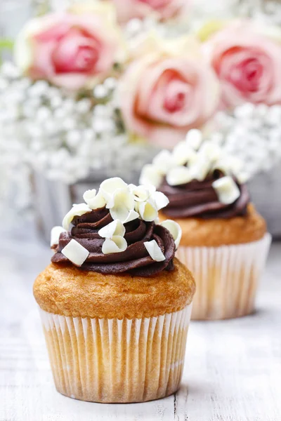 Chocolade cupcakes voor bruiloft receptie. Boeket van roze rozen — Stockfoto