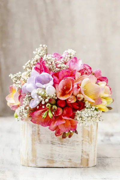 Bouquet of colorful freesia flowers in wooden shabby chic box. — Stock Photo, Image