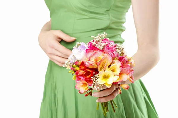 Jovem mulher em vestido verde segurando buquê de freesia colorido f — Fotografia de Stock