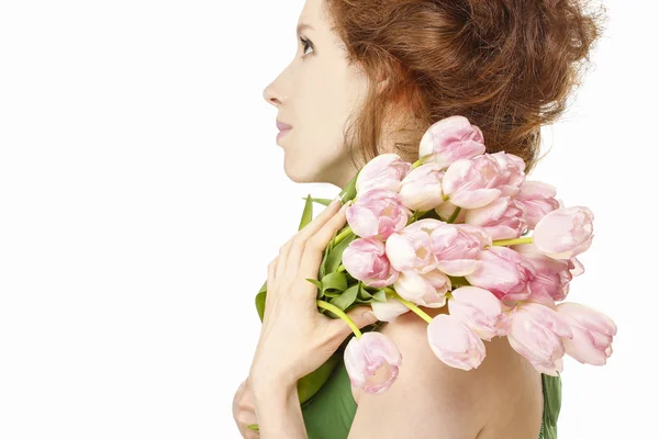 Junge Frau in grünem Kleid mit einem Strauß rosa Tulpen — Stockfoto