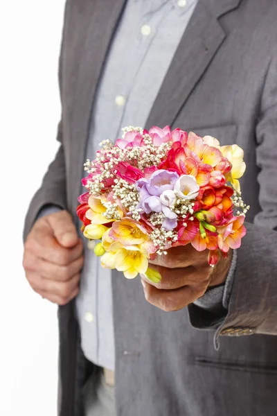 Man holding bouquet of colorful freesia flowers — Stock Photo, Image