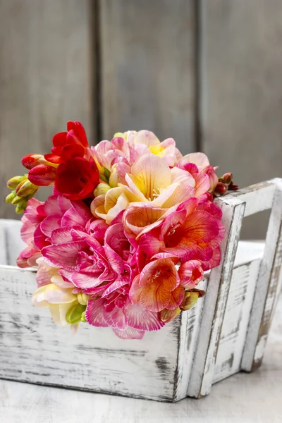 Bouquet of colorful freesia flowers in wooden shabby chic box. C — Stock Photo, Image