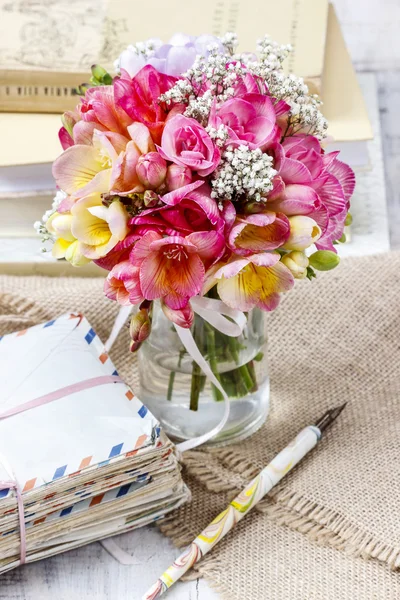 Bouquet of colorful freesia flowers in transparent glass vase. — Stock Photo, Image