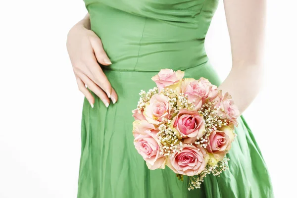 Giovane donna in abito verde con mazzo di rose rosa — Foto Stock