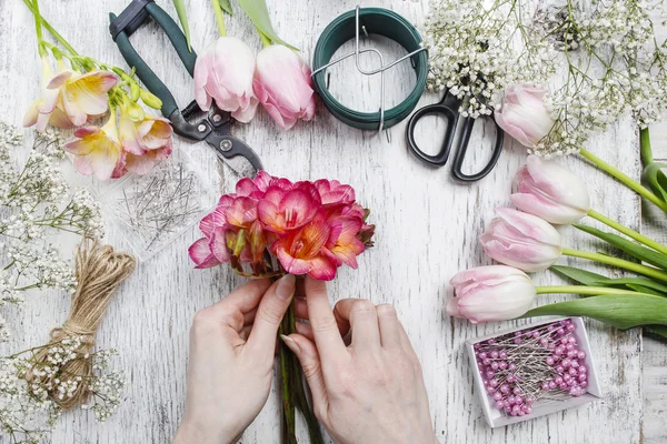 Florista en el trabajo. Mujer haciendo ramo de flores de primavera freesia —  Fotos de Stock