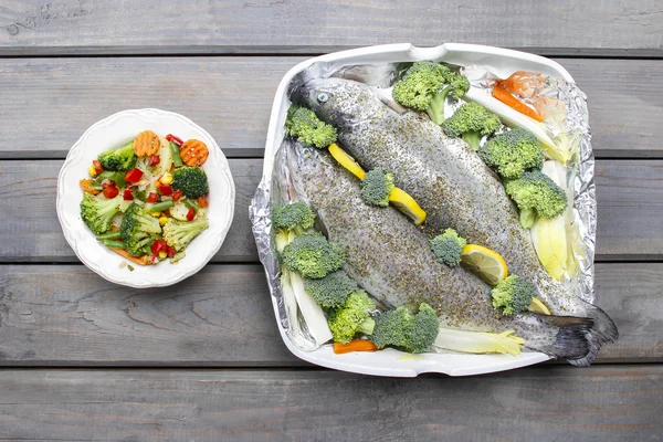 Dîner santé : truites et légumes. Table en bois, vue de dessus — Photo