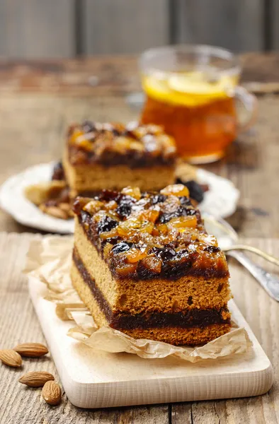 Delicious layer gingerbread cake decorated with dried fruits — Stock Photo, Image