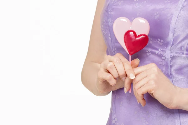 Beautiful young woman holding lollipop in heart shape. Symbol of — Stock Photo, Image