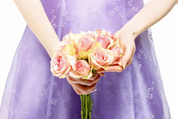 Družička v fialové šaty držení kytice růžových růží — Stock fotografie