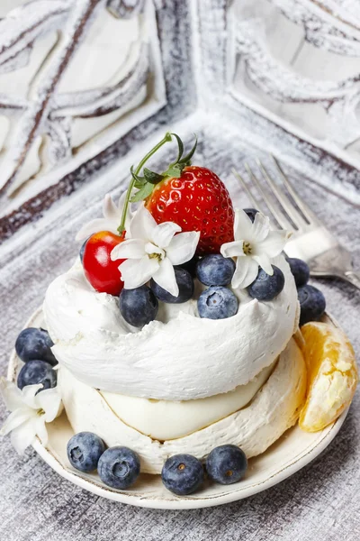 Meringue decorated with blueberries, strawberries and orange — Stock Photo, Image