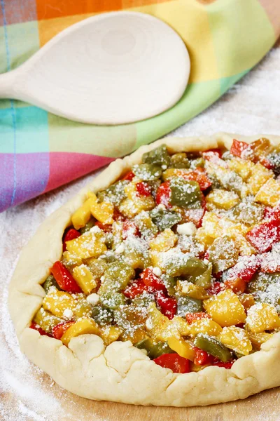 Vegetable galette on wooden kitchen board before baking. — Stock Photo, Image