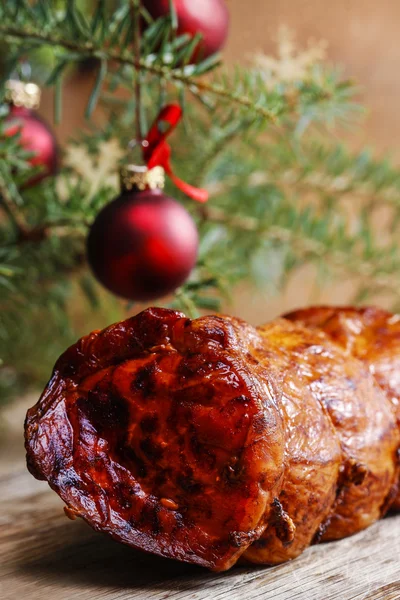Prosciutto affumicato di Natale sotto ramo di abete. Sfondo in legno, copia s — Foto Stock