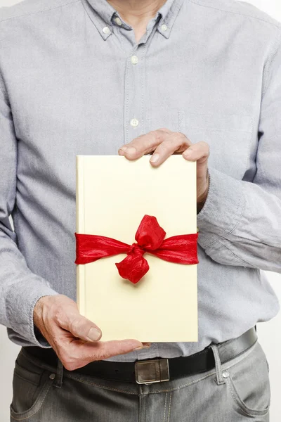 Adam bir kitap hediye olarak vermek — Stok fotoğraf