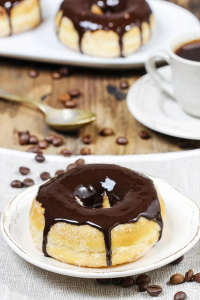 Вкусный пончик с шоколадом на деревянном столе — стоковое фото