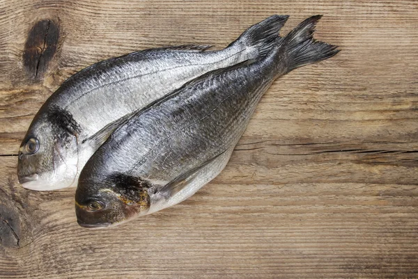 Gilt-head bream fish on wooden background. Mediterranean tavern, — Stock Photo, Image