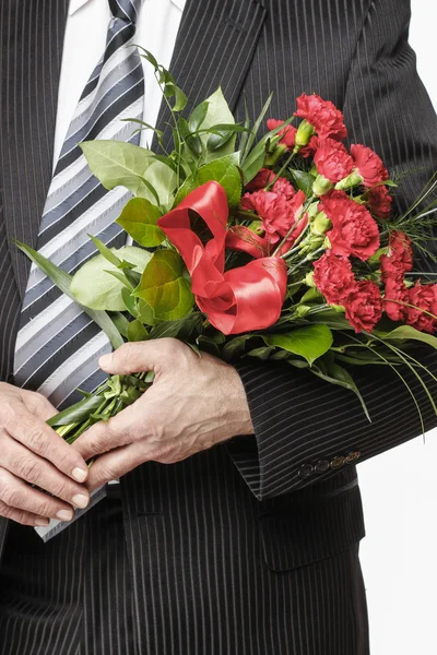 Uomo in possesso di bouquet di garofani rossi — Foto Stock