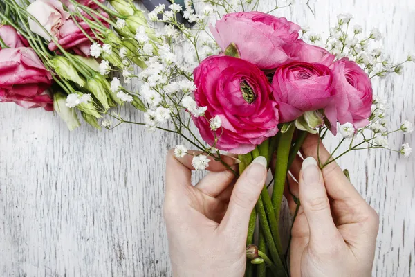 Fiorista al lavoro. Donna che fa bellissimo bouquet di rosa persiano — Foto Stock