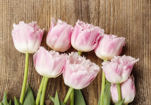 Bellissimi tulipani rosa e bianchi su sfondo di legno. Copia spazio — Foto Stock