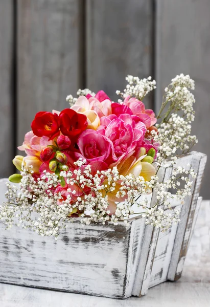 Bouquet of colorful freesia flowers in wooden shabby chic box. C — Stock Photo, Image