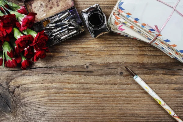 Writing a letter. Package of old letters and red carnation flowe — Stock Photo, Image