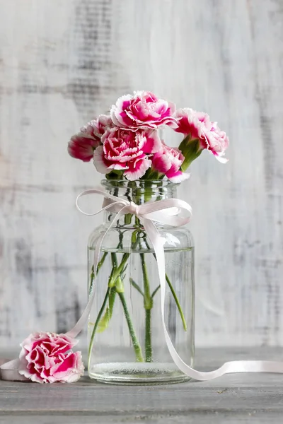 Bouquet of pink carnations in glass vase — Stock Photo, Image