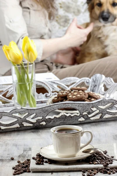 Tempo di rilassarsi: tazza di caffè sul tavolo, giovane donna che gioca w — Foto Stock