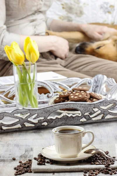 Tempo di rilassarsi: tazza di caffè sul tavolo, giovane donna che gioca w — Foto Stock