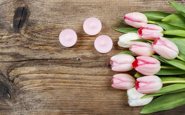 美丽的粉红色和白色郁金香和木坝上的香味的蜡烛 — 图库照片