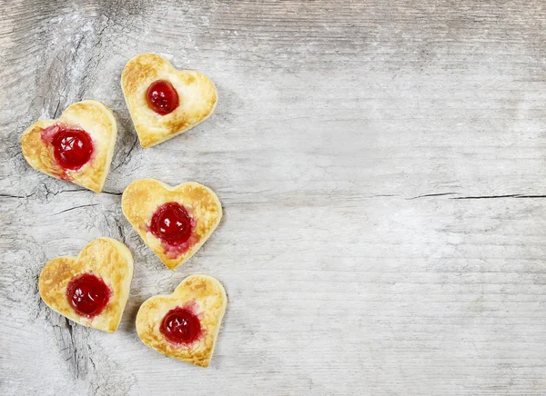 Puff pastry cookies in heart shape filled with cherries — Stock Photo, Image