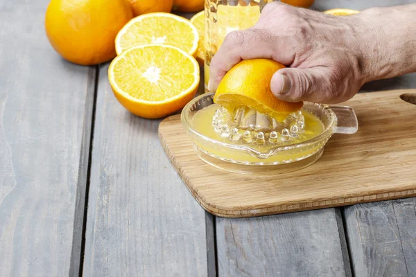 Squeezing oranges — Stock Photo, Image