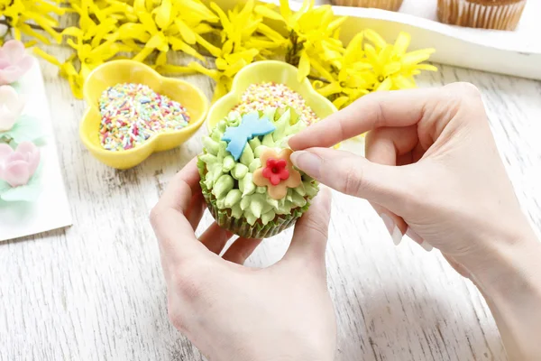 Woman decorates easter cupcakes — Stock Photo, Image