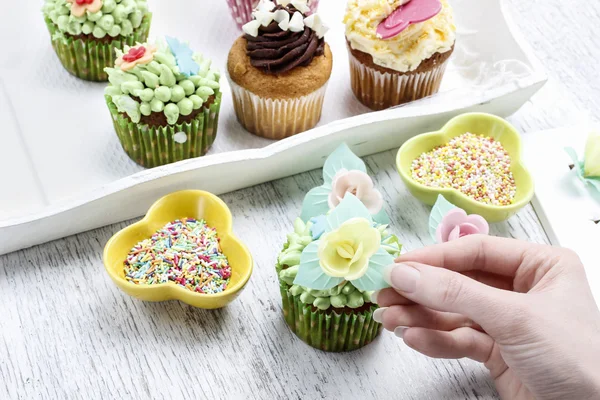 Woman decorates easter cupcakes — Stock Photo, Image