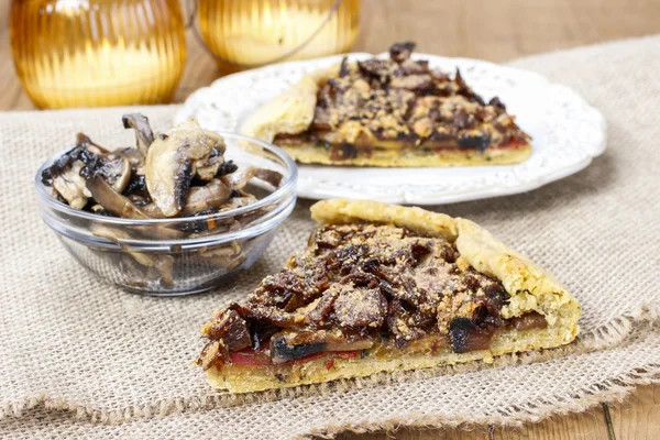 Bowl of raw mushrooms and mushroom galette in the background — Stock Photo, Image