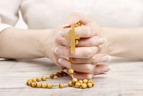 Vrouw met houten rozenkrans in mooie handen — Stockfoto