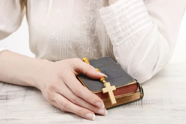 Mulher segurando Bíblia Sagrada e rosário de madeira — Fotografia de Stock