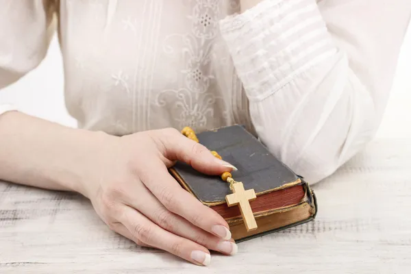 Mujer sosteniendo la Santa Biblia y rosario de madera — Foto de Stock