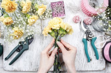 Çiçekçi iş başında. Sarı karanfil buketi yapma kadın