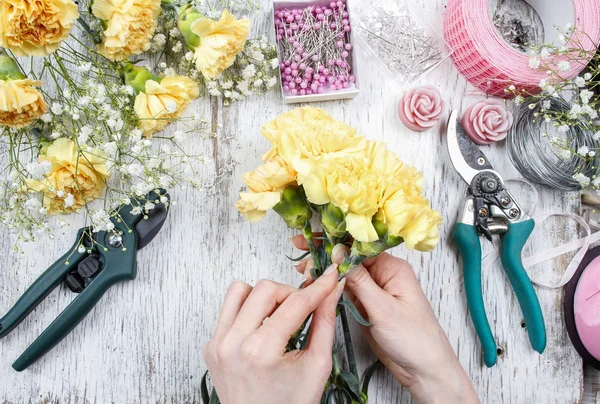 仕事で花屋。黄色のカーネーションの花束を作る女性 — ストック写真
