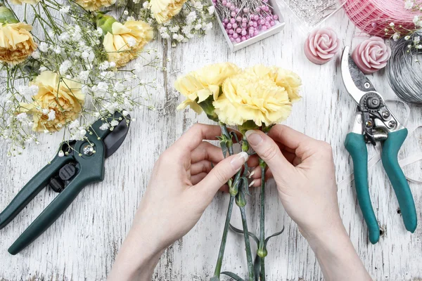 仕事で花屋。黄色のカーネーションの花束を作る女性 — ストック写真